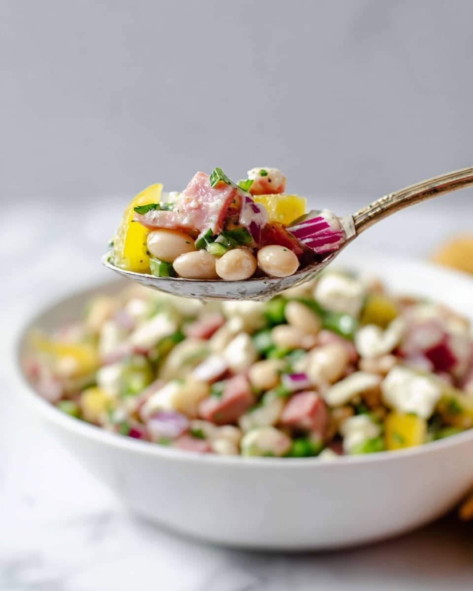 A close-up view of a spoon holding a mix of salad ingredients above a white bowl filled with the same salad, placed on a white marbled surface. The spoon's contents show layers of small white beans, light yellow pepper slices, pink bits of ham, green herbs, and small white cheese chunks with a creamy dressing visible on them. The bowl beneath contains a colorful mix of these ingredients including white beans, yellow peppers, red onions, fresh green herbs, and creamy white cheese pieces, all mixed together with a light dressing. The background is simple and blurred with a soft, light gray color. Photo taken with an iphone --ar 4:5 --v 7