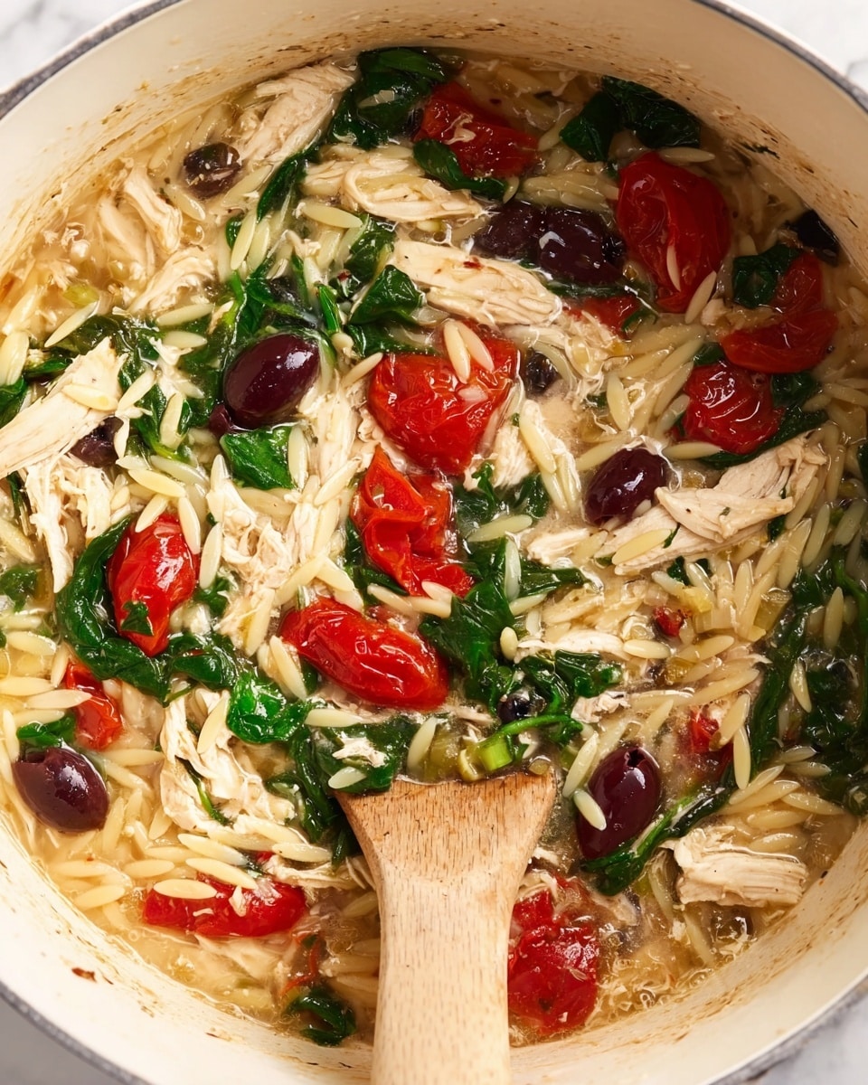 The image shows a close-up view of a warm dish in a white pot, consisting of several mixed layers. The bottom layer is pale yellow orzo pasta that looks soft and cooked, soaking in a light brown broth. Scattered throughout are bright green wilted spinach leaves adding a fresh color and texture. There are also deep purple Kalamata olives and small capers providing contrast. Bright red halves of cherry tomatoes sit on top, some cooked and slightly wrinkled. White shredded chicken chunks are spread evenly over the dish, blending with the pasta and vegetables. A wooden spoon stirs the ingredients gently from the left side. The pot’s interior has light stains from cooking, and the whole scene is set on a white marbled surface. photo taken with an iphone --ar 4:5 --v 7