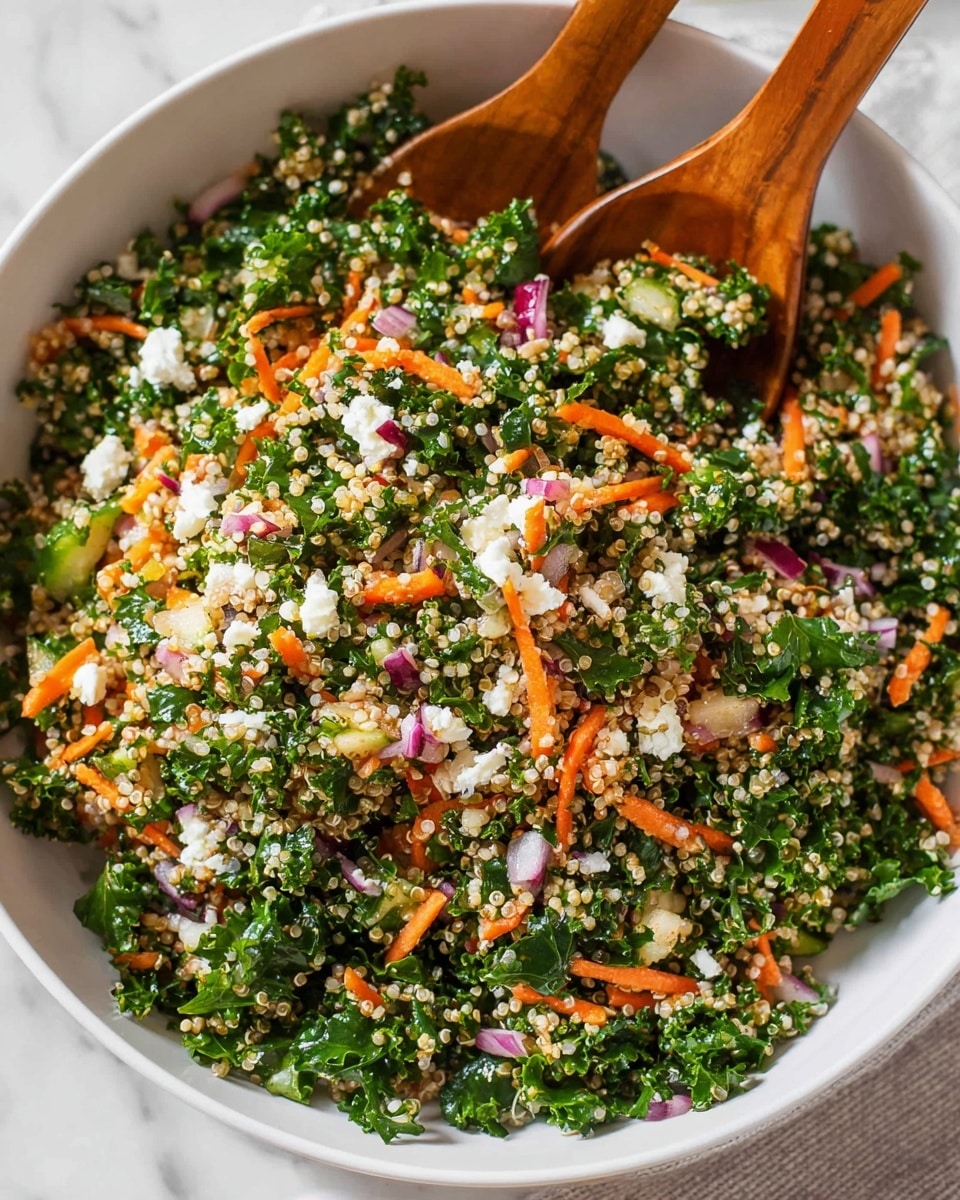 A large white bowl filled with a bright, fresh salad made of multiple layers: the base layer is curly kale in rich green color, mixed with small round grains of light beige quinoa spread evenly throughout, thin strips of bright orange carrots scattered on top. Small white crumbles of feta cheese and bits of red onion add pops of white and pinkish-purple color, all mixed together for a textured look. Two wooden-handled serving spoons are scooping a portion, showing the salad’s colorful and fresh appearance clearly. The bowl sits on a white marbled surface. photo taken with an iphone --ar 4:5 --v 7